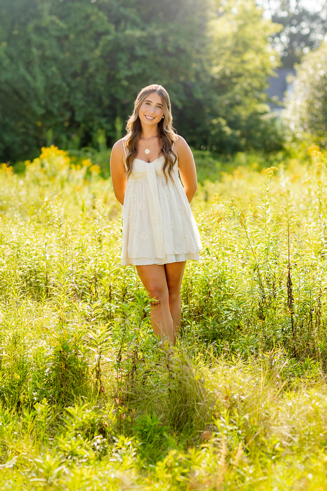 Senior giri in sundress in field at golden hour